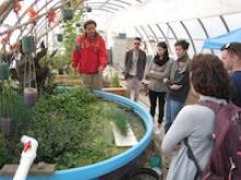 Students gathered in green house listening to lecture