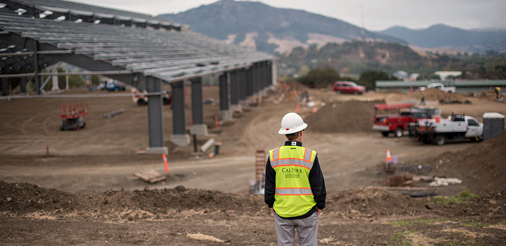 Construction worker overlooking the build site of the Oppenheimer Family Equine Center