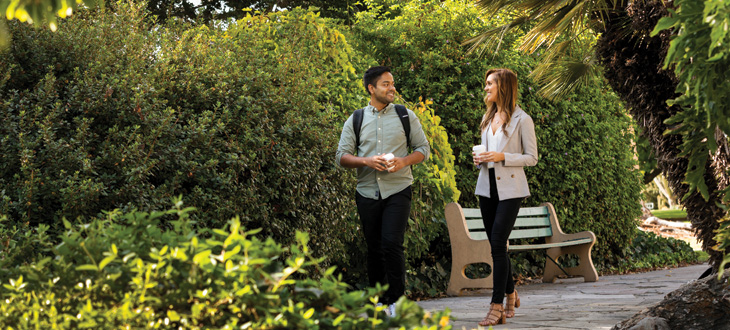 student and alumna networking as they stroll on a path