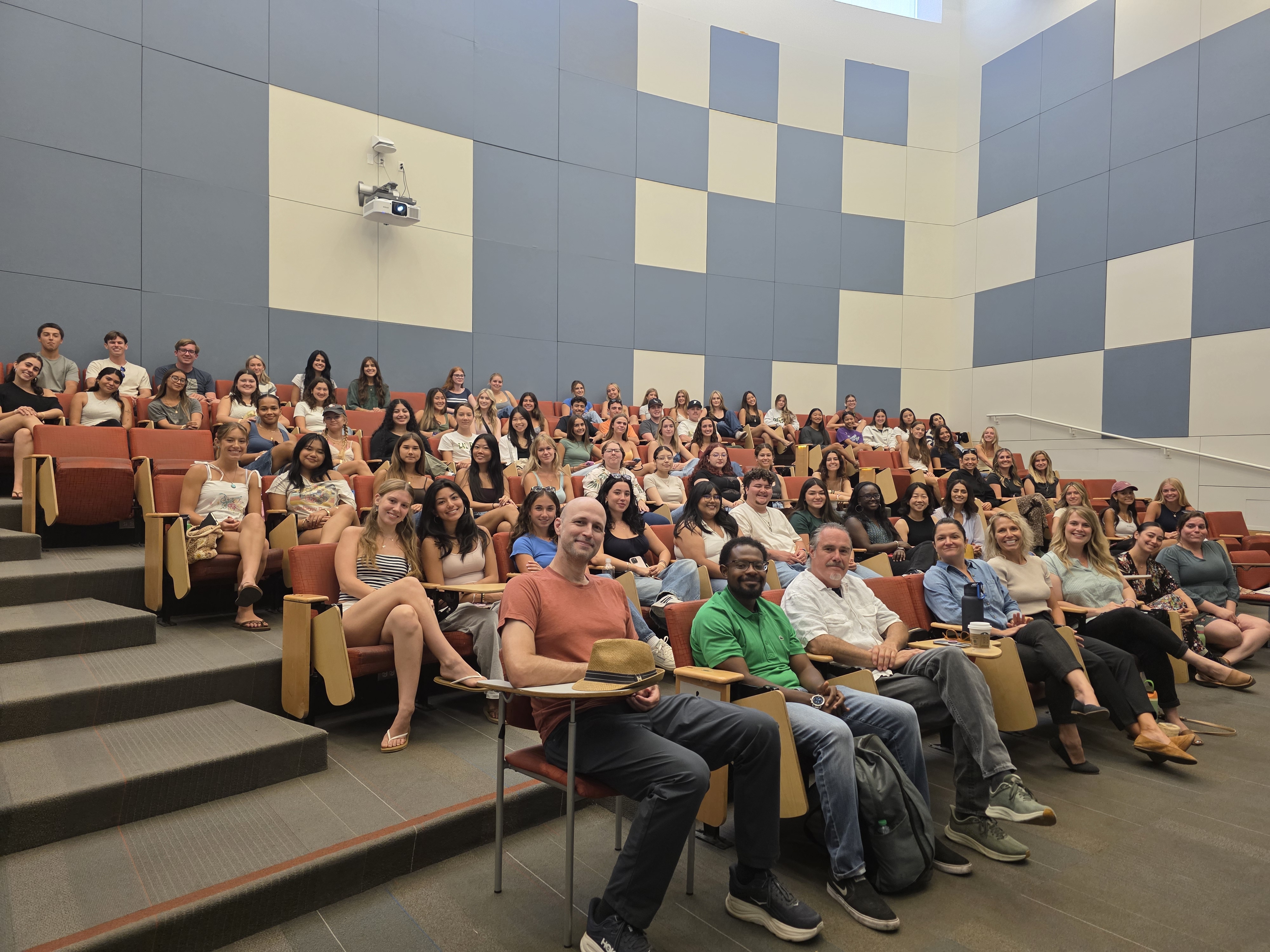 New COMS majors sitting in an auditorium smiling