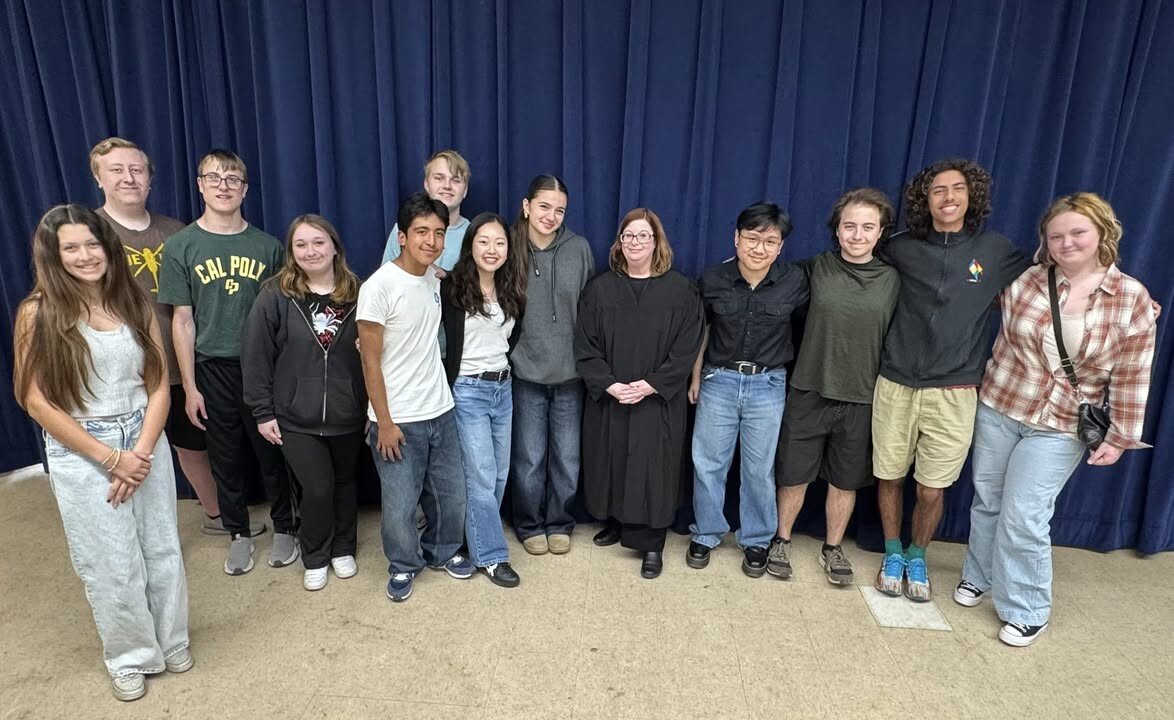 Judge O'Neill smiling with a group of high school students