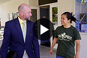 Dean Wendt walking with student with video play button