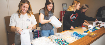  Cal Poly students Lucy Passaglia and Amelia Johnson, alumna Tayler Garis and biological sciences Professor Candace Winstead set up for a syringe exchange and overdose prevention program at the San Luis Obispo County Public Health Department. 