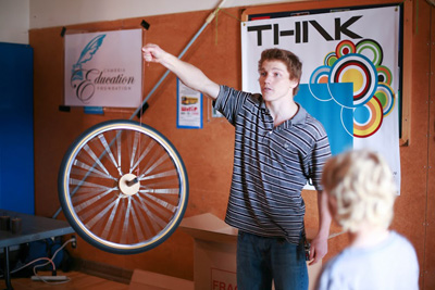 Student holding up a bicycle wheel with string