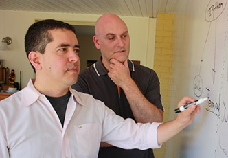 Two professors working at a white board