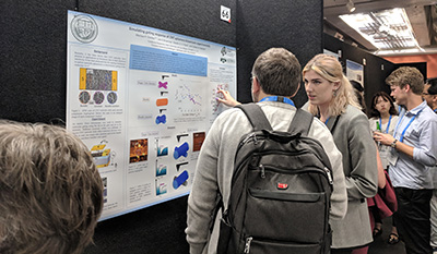 Marissa Dierkes explaining her research poster to a conference attendee