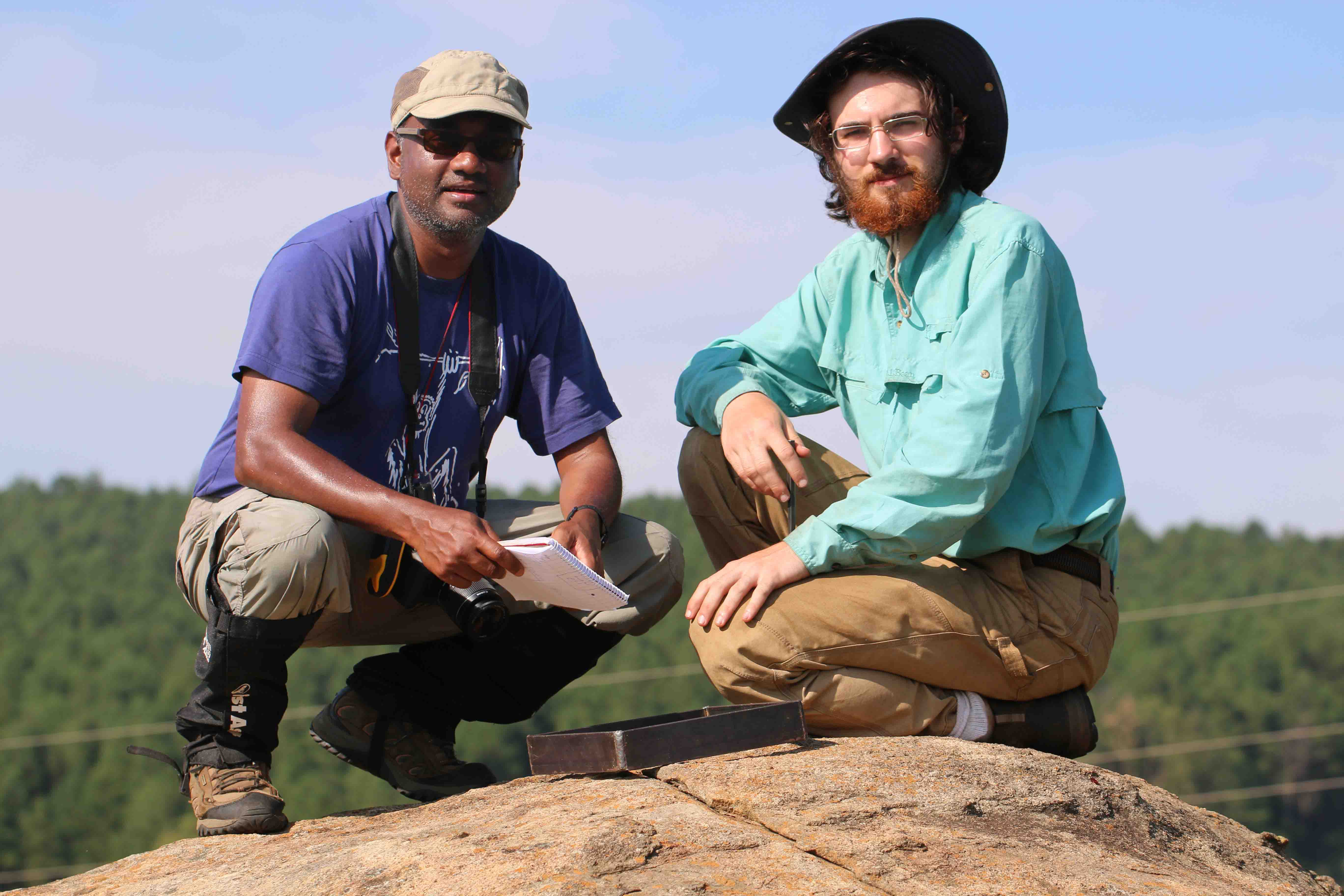 Nishi Rajakaruna (left) and Ian Medeiros collect lichen specimens on an outcropping of the rock serpentinite during an expedition in eastern South Africa.