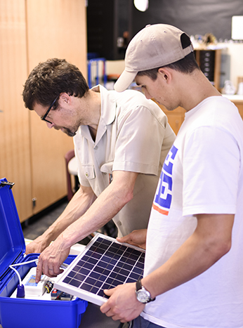 image. physics Professor Pete Schwartz and a student assemble the solar suitcase