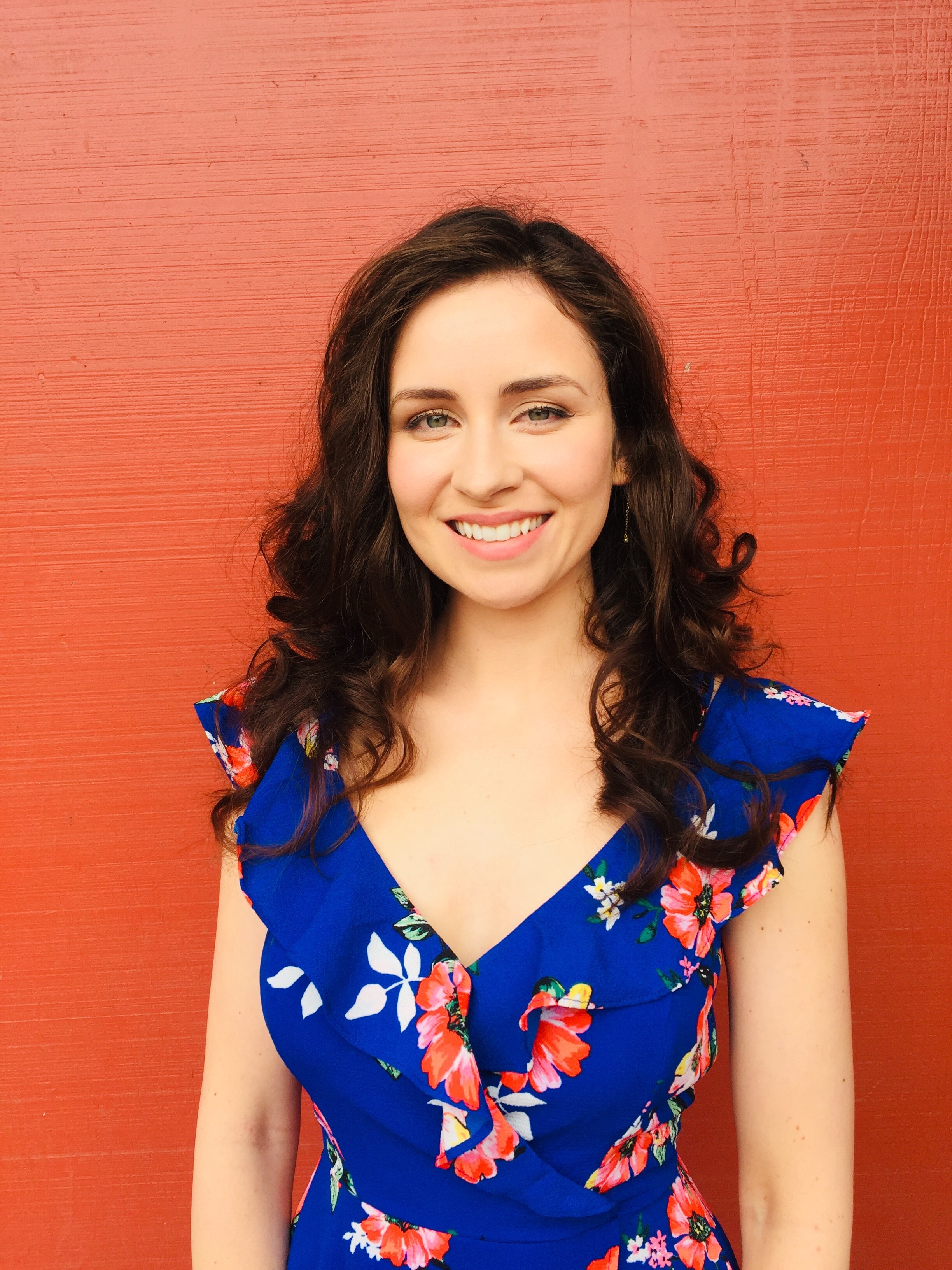 Headshot of Jana in front of a red wall