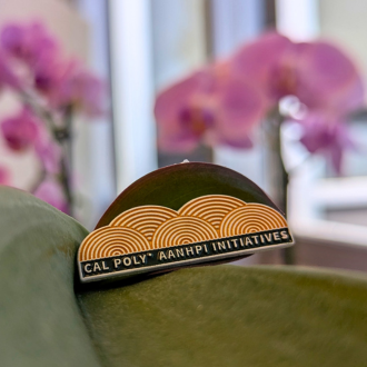 Close up of a pin of the Cal Poly AANHPI Initiatives logo.