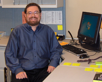 John Lee, sitting at his desk