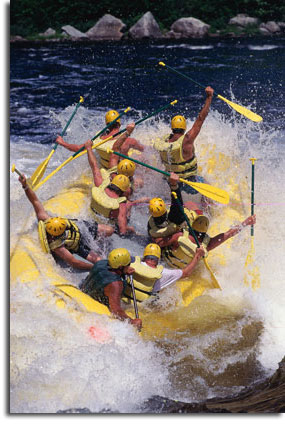 yellow raft with rafters fighting the rough water