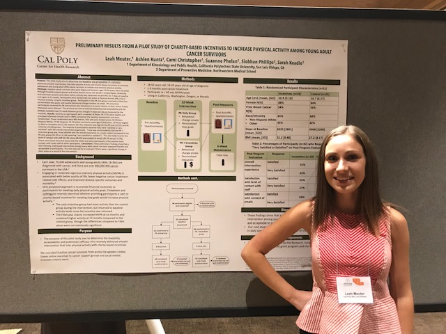 Leah Meuter smiling in front of a poster summarizing her research.