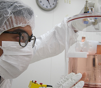 Students in clean room suit cleaning equipment