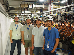 Professor and three students in equipment room wearing hard hats