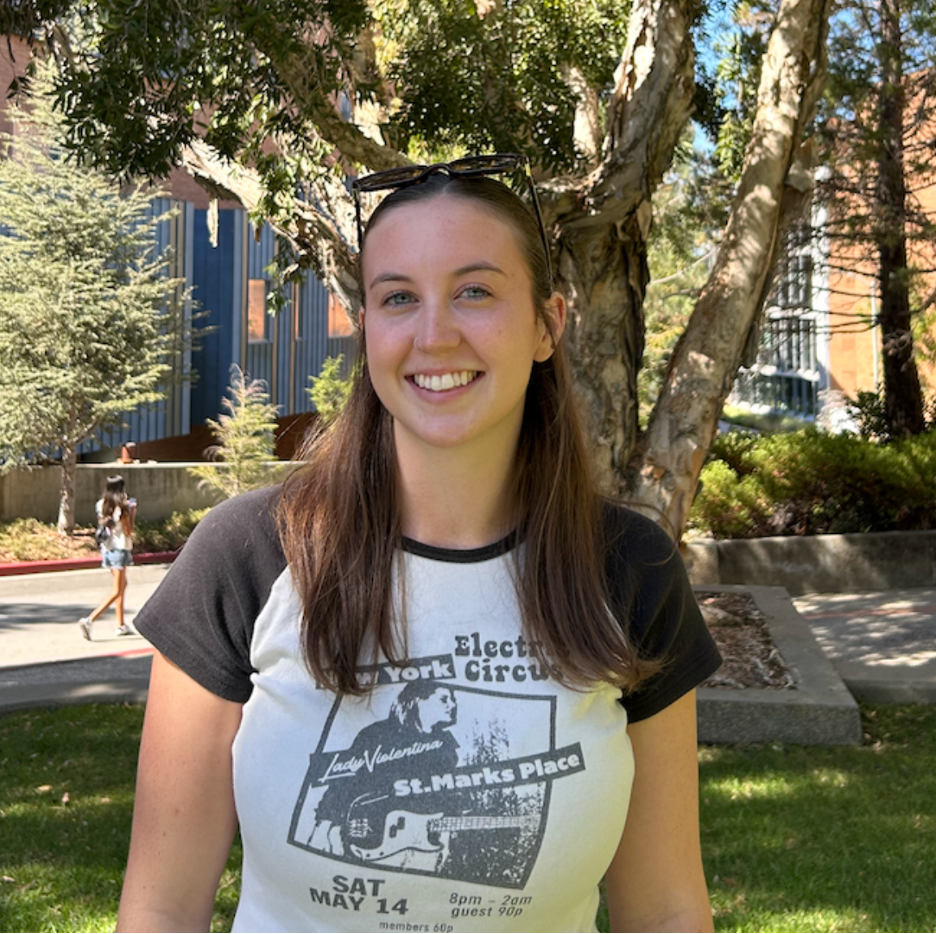 Photo of Cassidy standing in front of trees