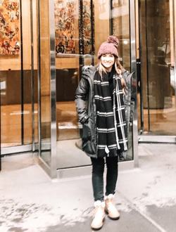 Jenna Harrelson in front of a building with glass walls and the address 5 Manhattan West