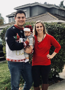 Mary Ellen DeHaven Rosales and her partner with their baby in front of their house