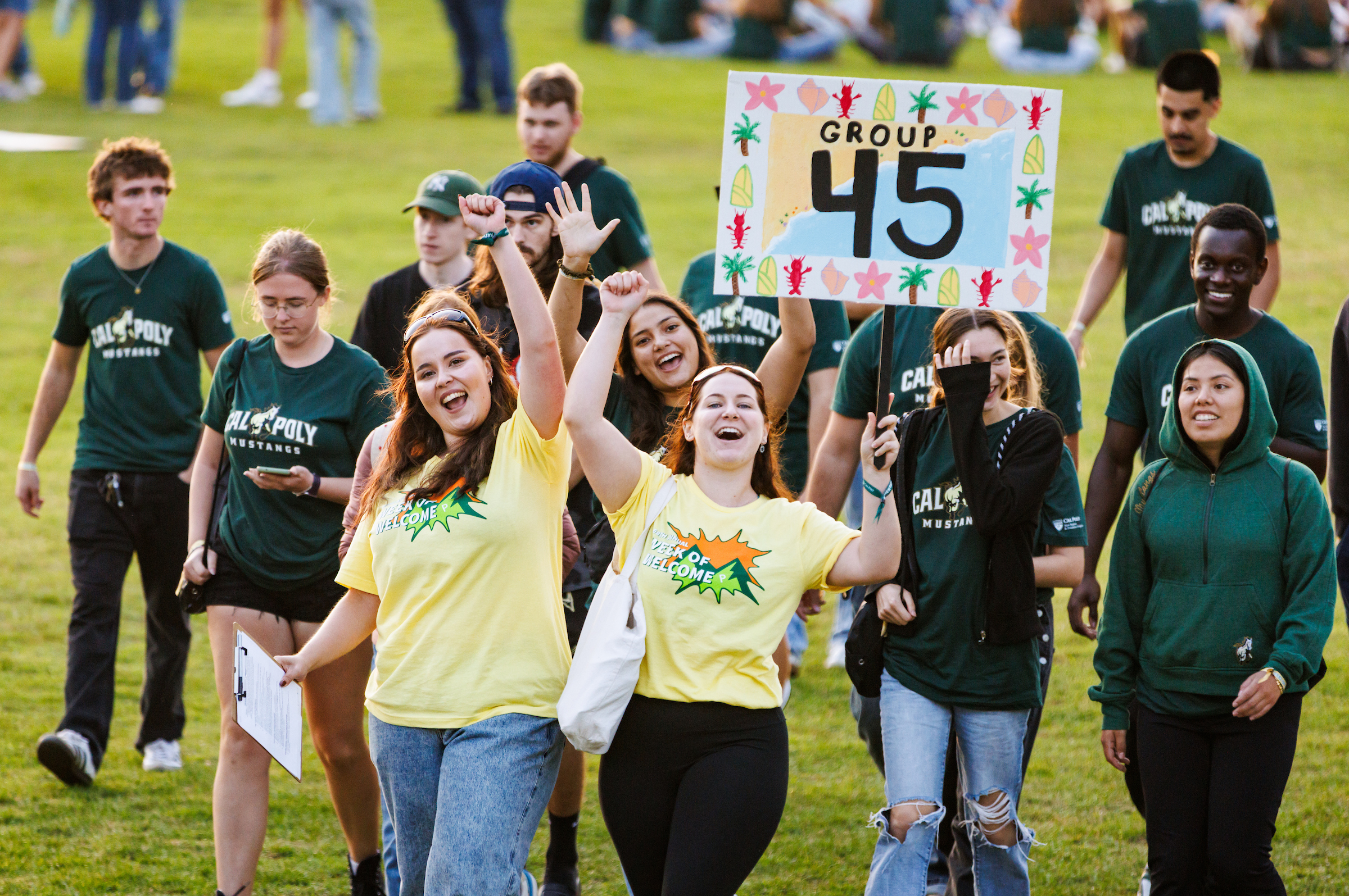 A group of students walk across the lower sports field during Week of Welcome grouping