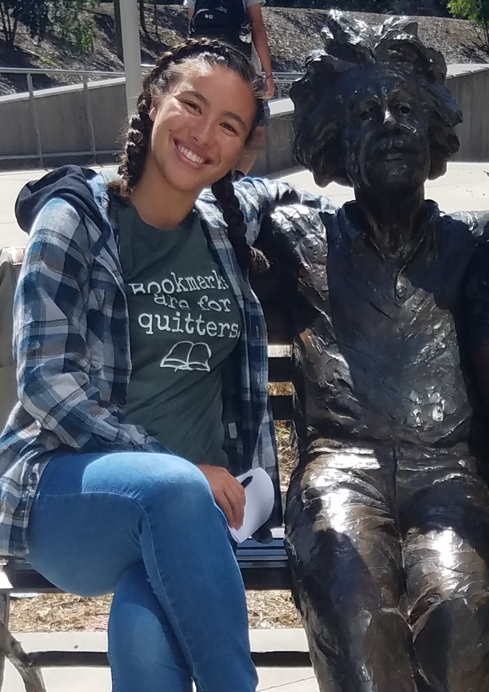 student Jayden smiling outside next to the Einstein statue